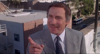 Movie still from “Life Stinks” (1991), directed by Mel Brooks – An older man wearing a suit and tie talking; Close Up shot, Over the shoulder angle