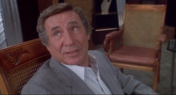 Movie still from “Life Stinks” (1991), directed by Mel Brooks – A person wearing a suit and tie; Close Up shot, Over the shoulder angle