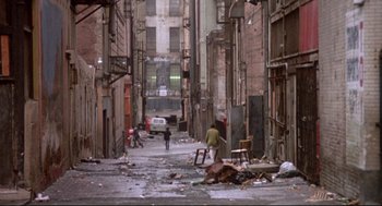 Movie still from “Life Stinks” (1991), directed by Mel Brooks – An alley with a lot of trash on the ground; Extreme Wide shot, High angle