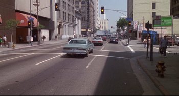 Movie still from “Life Stinks” (1991), directed by Mel Brooks – Cars are stopped at a red light on a city street; Extreme Wide shot, High angle