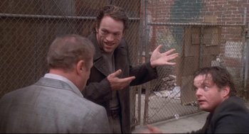 Movie still from “Life Stinks” (1991), directed by Mel Brooks – Two men are talking in front of a chain link fence; Medium shot, Over the shoulder angle