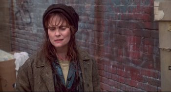 Movie still from “Life Stinks” (1991), directed by Mel Brooks – A woman wearing a hat standing in front of a brick wall; Close Up shot, High angle