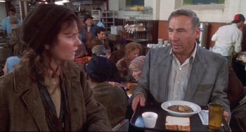 Movie still from “Life Stinks” (1991), directed by Mel Brooks – A man and a woman sitting at a table in front of a plate of food; Medium shot, Over the shoulder angle