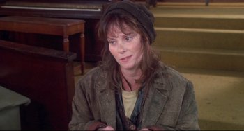 Movie still from “Life Stinks” (1991), directed by Mel Brooks – A woman wearing a hat sitting on a chair; Close Up shot, High angle
