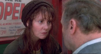 Movie still from “Life Stinks” (1991), directed by Mel Brooks – A woman wearing a hat looking at a man in the mirror; Close Up shot, Over the shoulder angle