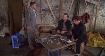 Movie still from “Life Stinks” (1991), directed by Mel Brooks – A group of men sitting around a table; Wide shot, High angle