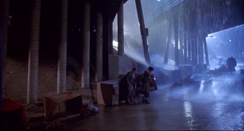 Movie still from “Life Stinks” (1991), directed by Mel Brooks – Two men are standing in a building with a hose; Extreme Wide shot, Low angle