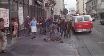 Movie still from “Life Stinks” (1991), directed by Mel Brooks – A group of people standing on the side of the street; Wide shot, High angle