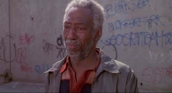 Movie still from “Life Stinks” (1991), directed by Mel Brooks – An older man with a gray beard is standing in front of a wall; Close Up shot, Low angle