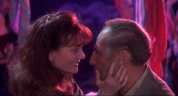Movie still from “Life Stinks” (1991), directed by Mel Brooks – A man and a woman face to face in front of a purple background; Close Up shot, Over the shoulder angle