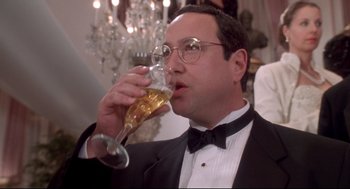 Movie still from “Life Stinks” (1991), directed by Mel Brooks – A man in a tuxedo drinking a glass of beer; Close Up shot, Low angle