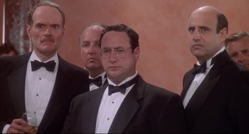 Movie still from “Life Stinks” (1991), directed by Mel Brooks – A group of men in tuxedos standing next to each other; Medium shot, Low angle