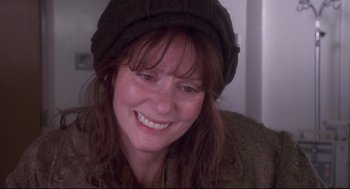 Movie still from “Life Stinks” (1991), directed by Mel Brooks – A person wearing a hat smiling; Close Up shot, Over the shoulder angle