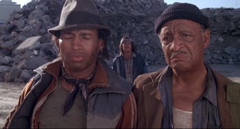 Movie still from “Life Stinks” (1991), directed by Mel Brooks – A group of men standing next to each other; Close Up shot, Low angle