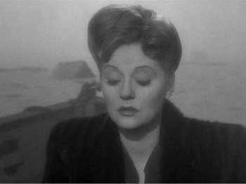 Movie still from “Lifeboat” (1944), directed by Alfred Hitchcock – An old photo of an older woman in a black jacket; Close Up shot, Over the shoulder angle