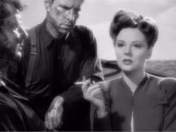 Movie still from “Lifeboat” (1944), directed by Alfred Hitchcock – A man and a woman are smoking a cigarette together; Close Up shot, Over the shoulder angle