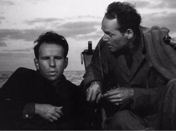 Movie still from “Lifeboat” (1944), directed by Alfred Hitchcock – Two men sitting next to each other on a boat; Medium shot, High angle