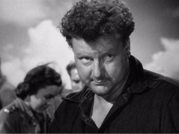 Movie still from “Lifeboat” (1944), directed by Alfred Hitchcock – An old photo of a man with curly hair looking at the camera; Close Up shot, Low angle