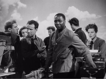Movie still from “Lifeboat” (1944), directed by Alfred Hitchcock – A black and white photo of a group of men and women; Medium shot, Low angle