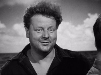 Movie still from “Lifeboat” (1944), directed by Alfred Hitchcock – Black and white photograph of a man smiling; Close Up shot, High angle