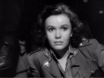 Movie still from “Lifeboat” (1944), directed by Alfred Hitchcock – A woman in a military jacket is looking at the camera; Close Up shot, High angle