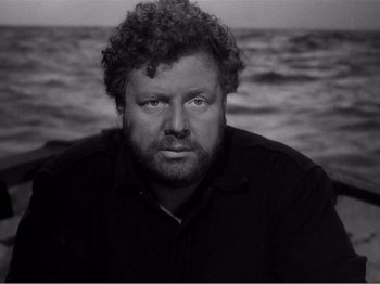 Movie still from “Lifeboat” (1944), directed by Alfred Hitchcock – Black and white photograph of a man in front of a body of water; Close Up shot, High angle