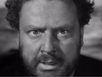 Movie still from “Lifeboat” (1944), directed by Alfred Hitchcock – Black and white photograph of a man looking angry; Close Up shot, High angle