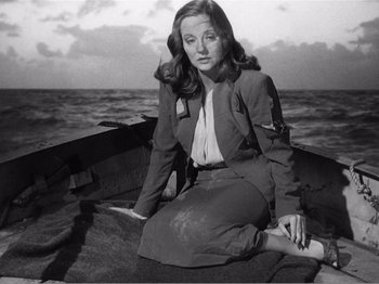 Movie still from “Lifeboat” (1944), directed by Alfred Hitchcock – A black and white photo of a woman sitting in a boat; Medium shot, High angle