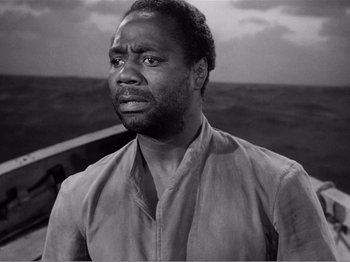 Movie still from “Lifeboat” (1944), directed by Alfred Hitchcock – A black and white photo of a man looking sad; Close Up shot, Low angle