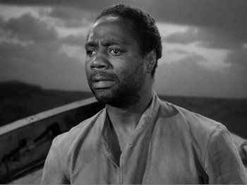 Movie still from “Lifeboat” (1944), directed by Alfred Hitchcock – A black and white photo of a man looking at the camera; Close Up shot, Low angle