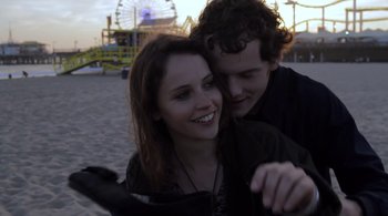 A man and a woman are hugging on the beach