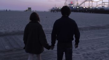 Movie still from “Like Crazy” (2011), directed by Drake Doremus – A man and a woman holding hands on the beach; Medium shot, Over the shoulder angle