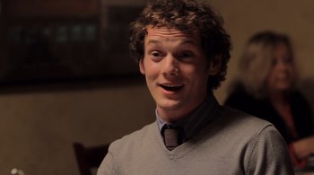 Movie still from “Like Crazy” (2011), directed by Drake Doremus – A young man wearing a gray sweater and a tie; Close Up shot, Over the shoulder angle