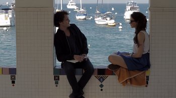 Movie still from “Like Crazy” (2011), directed by Drake Doremus – A man and a woman sitting next to each other on a ledge; Medium shot, Over the shoulder angle