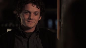 Movie still from “Like Crazy” (2011), directed by Drake Doremus – A man with curly hair is smiling for the camera; Close Up shot, Over the shoulder angle