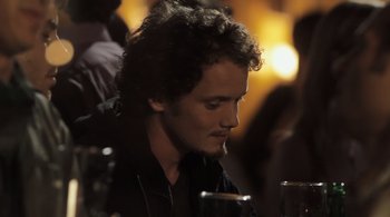 Movie still from “Like Crazy” (2011), directed by Drake Doremus – A person sitting at a table with a drink; Close Up shot, Over the shoulder angle