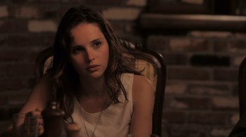Movie still from “Like Crazy” (2011), directed by Drake Doremus – A beautiful young woman sitting in a chair; Close Up shot, Over the shoulder angle