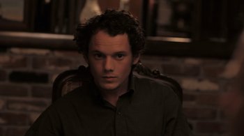 Movie still from “Like Crazy” (2011), directed by Drake Doremus – A man sitting in a chair in front of a brick wall; Close Up shot, Over the shoulder angle