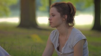 Movie still from “Like Crazy” (2011), directed by Drake Doremus – A woman sitting in the grass looking to her left; Close Up shot, Low angle