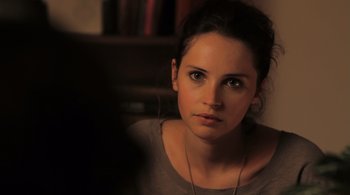 Movie still from “Like Crazy” (2011), directed by Drake Doremus – A beautiful young lady sitting in front of a bookshelf; Close Up shot, Over the shoulder angle