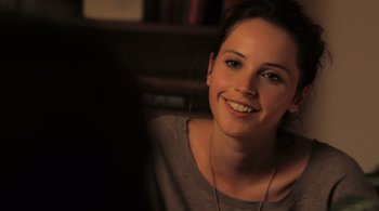 Movie still from “Like Crazy” (2011), directed by Drake Doremus – A beautiful young lady sitting in front of a bookshelf; Close Up shot, Over the shoulder angle
