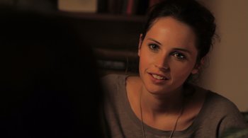 Movie still from “Like Crazy” (2011), directed by Drake Doremus – A beautiful young lady sitting in front of a bookshelf; Close Up shot, Over the shoulder angle