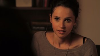 Movie still from “Like Crazy” (2011), directed by Drake Doremus – A beautiful young lady sitting in front of a bookshelf; Close Up shot, Over the shoulder angle
