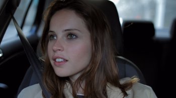 Movie still from “Like Crazy” (2011), directed by Drake Doremus – A woman sitting in the back seat of a car; Close Up shot, Over the shoulder angle