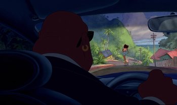 Movie still from “Lilo & Stitch” (2002), directed by Dean DeBlois – A man in a suit and tie in a car with another man; Extreme Wide shot, Over the shoulder angle