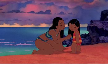 Movie still from “Lilo & Stitch” (2002), directed by Dean DeBlois – A woman and a little girl sitting on the beach; Medium shot, High angle