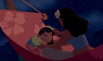 Movie still from “Lilo & Stitch” (2002), directed by Dean DeBlois – An animated scene of a girl laying on the ground with an adult; Wide shot, High angle
