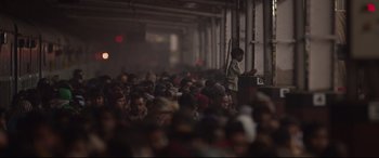 Movie still from “Lion” (2016), directed by Garth Davis – A crowd of people sitting and standing in a building; Extreme Wide shot, High angle