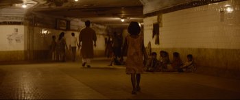 Movie still from “Lion” (2016), directed by Garth Davis – A group of people walking down a hallway; Wide shot, High angle