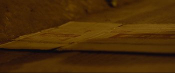 Movie still from “Lion” (2016), directed by Garth Davis – View of a piece of cardboard; Extreme Close Up shot, High angle